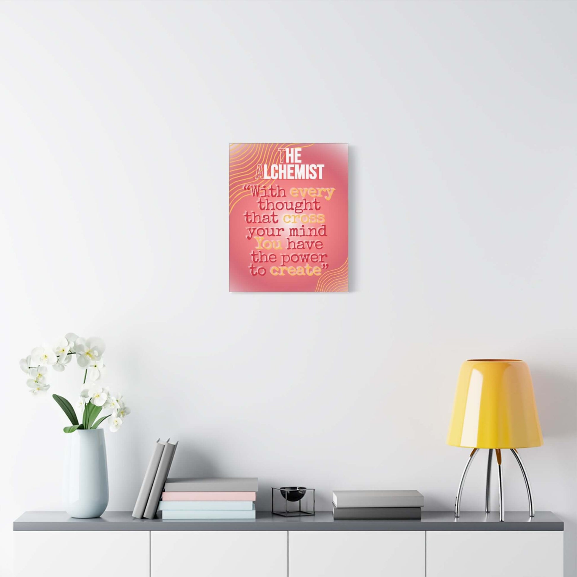Inspirational quote canvas wall art with a coral-pink background and hand-lettered text on display in a modern room.